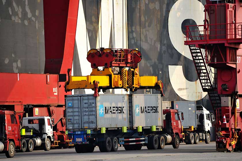 A crane vehicle lifts containers to be shipped abroad